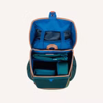 Draufsicht auf das Finkid Schulranzen Set im Dschungel-Mix bestehend aus einem organisierten grünen Rucksack mit blauem Innenleben hellbrauner Zierleiste mehreren Fächern für Ordner einer bestückten Federmappe Schlampermäppchen und Sportbeutel.