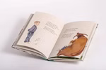 Ein aufgeschlagenes Exemplar von "Der kleine Hirtenjunge - eine Erzählung über Liebe Verbundenheit und Mitgefühl" von Kösel zeigt auf der linken Seite einen Jungen mit einem weißen Kaninchen und auf der rechten Seite ein braunes Tier mit einem kleinen Kani