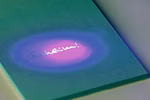 Das Notizbuch Detektiv Geheimcodestift aus dem moses. Verlag zeigt in der Mitte des blauen Einbands den Schriftzug "Geheim!" der unter UV-Licht weiß leuchtet und den Text lila umgibt.