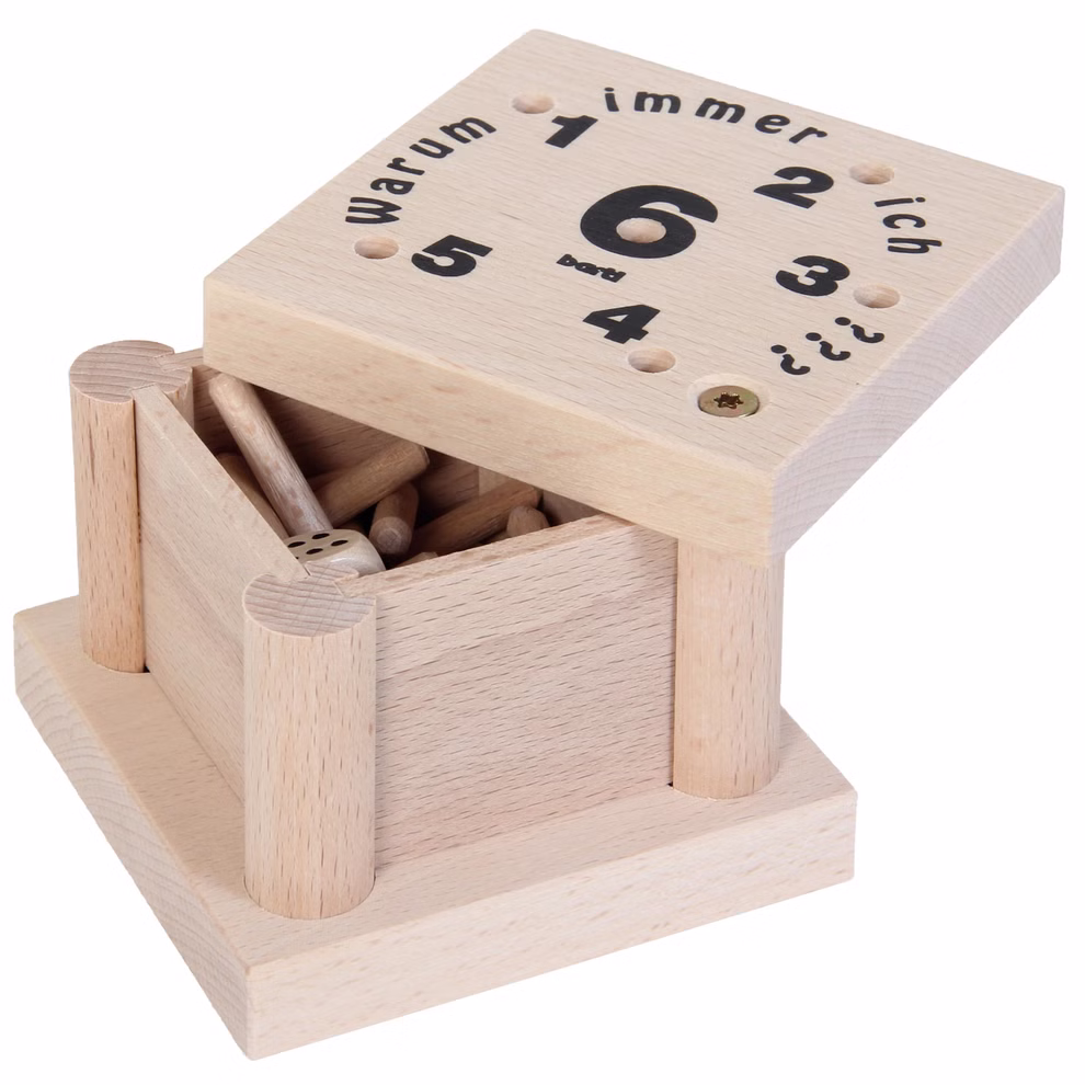Bartl Warum immer ich? Würfelspiel_31721 Eine teilweise geöffnete Holzkiste mit der Aufschrift "Warum immer ich?" von Bartl zeigt im Inneren Wäscheklammern und auf dem Deckel Zahlen Punkte und einen deutschen Text. Dies ist das "Warum immer ich? Würfelspiel.