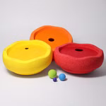 Grimm's GRIMM’S x Stapelstein® Kullerscheiben rot gelb orange _31799 Drei Grimm's x Stapelstein® Kullerscheiben in den Farben Rot Gelb und Orange mit Mittelloch sind auf einer weißen Fläche angeordnet davor drei kleine grüne blaue und lila Kugeln.