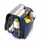 hukkepack Schulranzen Leder Blau Kompakt _32598 Der hukkepack Schulranzen Leder Blau Kompakt zeichnet sich durch übersichtliche Fächer und helle Nähte aus. In der offenen Klappe befinden sich Bücher ein Notizbuch eine Wasserflasche eine gelbe Brotdose und ein Plüschhundespielzeug.