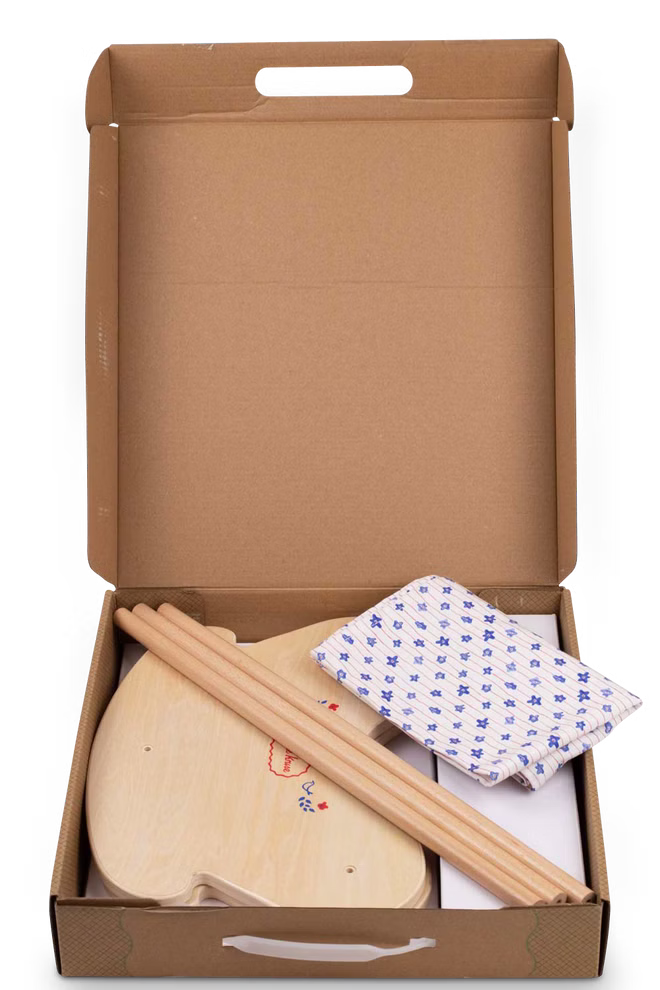 Käthe Kruse Waldorf Puppenwiege Holz_33066 Die Käthe Kruse Waldorf Puppenwiege Holz besteht aus einem palettenförmigen Holzsockel zwei Holzstäben und einem gefalteten weißen Tuch mit blauen Mustern in einer offenen Kartonschachtel.