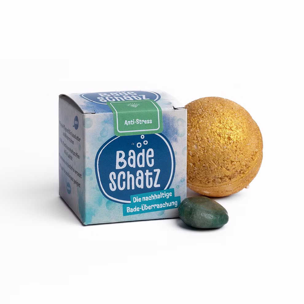 BadeSchatz Anti-Stress BadeSchatz Anti-Stress Badebombe mit Goldstaub und Aventurin Edelstein neben papierbasierter Verpackung.
