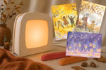 Toverlux Lampe aus hellem Holz mit drei herbstlichen Waldorfkind Postkarten und zwei farbigen Kartenständern auf weißem Hintergrund.