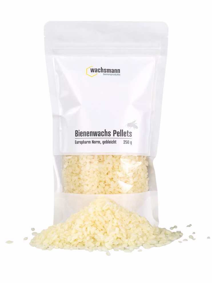Bienenwachs-Pastillen, weiß Wiederverschließbarer 250-g-Beutel mit weißen Bienenwachspastillen und lose aufgeschütteten Pastillen davor.