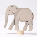 Der Grimms Geburtstagsstecker Elefant ist eine helle hölzerne Elefantenfigur mit einfachen schwarzen Details die auf einem kleinen runden Holzsockel vor einem weißen Hintergrund steht.