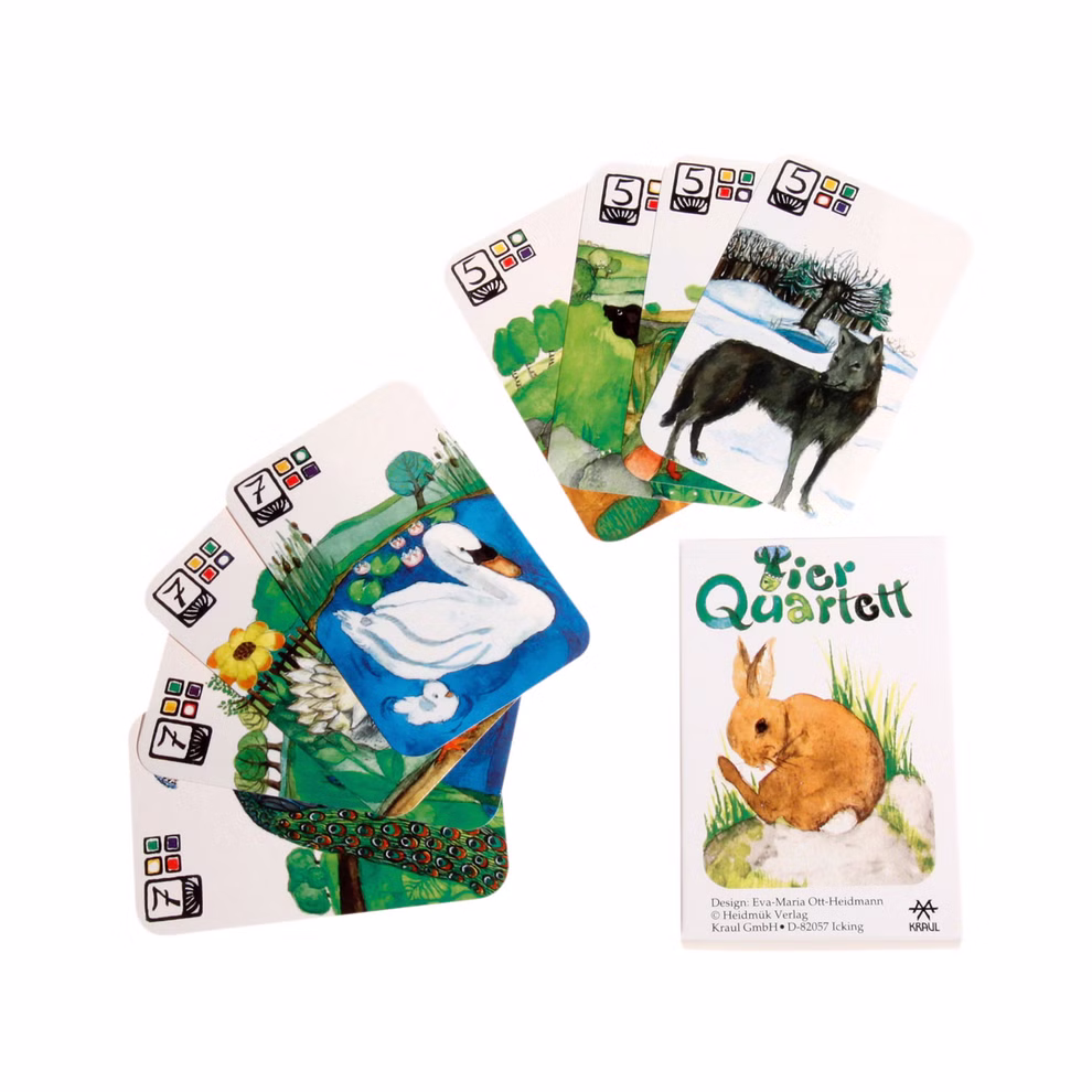 Kraul Tierquartett _2024 Neben der Schachtel befindet sich ein Satz illustrierter Tierspielkarten von Kraul Tierquartett die Zeichnungen eines Kaninchens eines Schwans eines Hundes und anderer Tiere zeigen jeweils mit farbigen Symbolen und Zahlen in den Ecken.