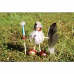Eine skurrile Figur aus Kastanien Federn und Stöcken steht im Gras und hält eine Feder und einen Stock mit blauer Spitze in der Hand - gebastelt mit dem Kids at Work Holz und Kastanienbohrer 3er-Set.