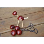 Eine kleine Tierfigur aus dem "Holz und Kastanienbohrer 3er-Set" von Kids at Work steht auf einer Holzfläche neben drei Kastanien und zwei alten Schlüsseln.