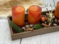 Orange Adventskerzen mit goldenem Hirsch auf braunem Holztablett als Weihnachtsgesteck zur Dekoration  3