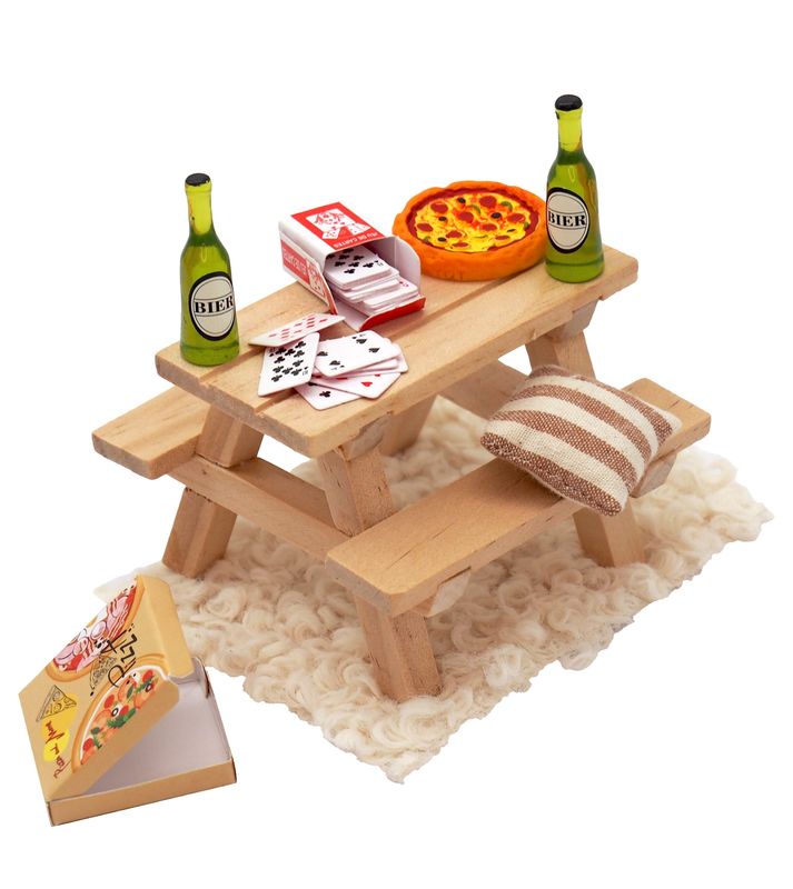 Tisch mit Bänken mit Bierflaschen und Pizza