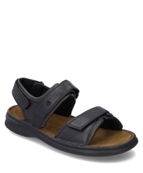 The black sandal features a practical Velcro closure and is made of high-quality material. It is equipped with a comfortable brown footbed ideal for daily comfort.