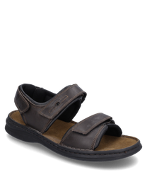 La sandale est de couleur moro-noire et est fabriquée en cuir robuste. Elle dispose d'une fermeture velcro pratique pour un enfilage et un retrait faciles.