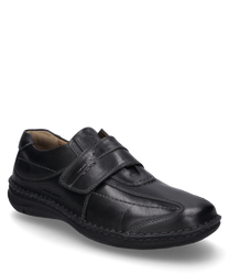 Black leather shoe with Velcro closure. The shoe is characterized by its simple design and robust stitching details.
