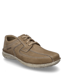 La scarpa in similpelle beige si distingue per la sua discreta allacciatura. Le cuciture visibili e il bordo imbottito conferiscono un aspetto casual e confortevole.