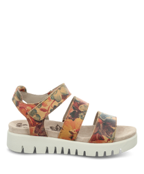 La sandale a un motif floral dans des tons chauds sur un fond beige. Elle dispose d'une fermeture velcro et d'une semelle profilée gris clair pour une meilleure adhérence.