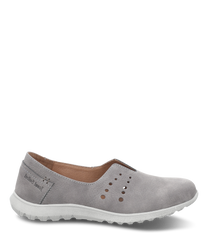 Mocasines grises de suave imitación de cuero con cómoda suela de goma blanca. El zapato tiene una entrada sin cierre y un patrón de perforaciones decorativas en la parte superior.