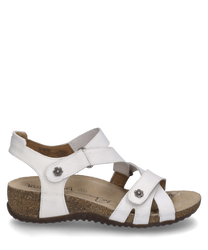 White sandal with Velcro made of smooth leather. Features include decorative metal buttons in flower shape and a comfortable cork sole with a slight elevation.