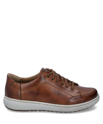 La sneaker en combinaison cognac présente une surface en cuir lisse avec des coutures claires et une semelle en caoutchouc blanche stable. Les caractéristiques particulières sont les lacets marron et la couture discrète qui donnent à la chaussure un look é