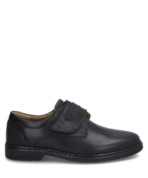 El zapato de media caña es negro y está hecho de un material suave con un cierre de velcro para facilitar su puesta y retirada. Tiene un diseño simple y elegante que lo hace ideal para ocasiones formales.