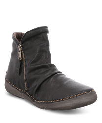 Die abgebildete Stiefelette besteht aus schwarzem Leder und hat einen seitlichen Reißverschluss. Sie zeichnet sich durch eine weiche geraffte Struktur und eine genähte Sohle in Kontrastfarbe aus.