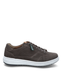 La chaussure à lacets en marron foncé est fabriquée en cuir de haute qualité avec un laçage et est équipée d'une semelle blanche et structurée. Le design présente des perforations discrètes sur le côté qui assurent une meilleure ventilation.
