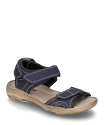 Die Sandale hat ein dunkelblaues Obermaterial mit hellen Ziernähten und einem beigen Sohlenrand. Sie verfügt über Klettverschlüsse für einfaches An- und Ausziehen und bietet einen lässigen komfortablen Look.
