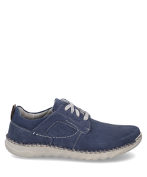 Un zapato azul de ante con cordones blancos y costuras claras en contraste. El zapato tiene una suela blanca flexible y orificios laterales para la transpiración.