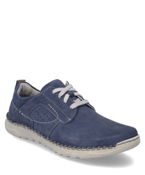 Un zapato azul de ante con cordones blancos y costuras claras en contraste. El zapato tiene una suela blanca flexible y orificios laterales para la transpiración.