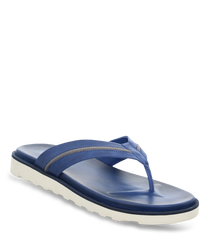 Tongs bleues avec des sangles larges et rembourrées et une semelle blanche. Le matériau a un aspect lisse et robuste parfait pour l'été.