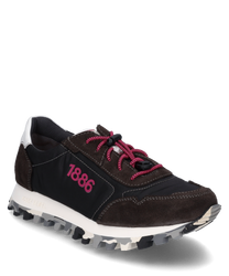 La sneaker est fabriquée en matériau noir lisse avec des accents en daim marron. Elle possède un laçage rose frappant et une semelle blanche avec des détails gris ainsi que le chiffre "1886" sur le côté.