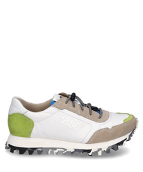 Moderne sneaker met veters gemaakt van wit leer met grijze en groene suède accenten. De schoen heeft een opvallende gekartelde zool en is versierd met het cijfer "1886" aan de zijkant.