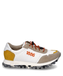 De sneaker van glad wit materiaal heeft gekleurde accenten in geel en lichtbruin suède. Opvallende oranje veters en het getal 1886 sieren de zijkant terwijl de zool een opvallend profiel heeft.