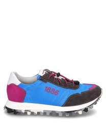 Der Sneaker hat eine Schnürung und besteht aus einem Mix aus blauem braunem und pinkem Material. Auffällig sind die weiße Fersenkappe und die kontrastreiche Sohle mit grobem Profil.