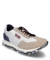 De sneaker met veters combineert witte blauwe en beige suède en textielmaterialen. Kenmerkende details zijn de bruine veters en het cijfer "1886" aan de zijkant aangevuld met een profielzool voor optimale grip.