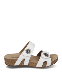 Witte sandaal met klittenbandsluiting versierd met metalen bloemen op de banden. De zool is van kurk wat zorgt voor extra comfort.