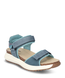 La sandalia tiene un cierre de velcro y está hecha de material textil azul. Se caracteriza por una cómoda suela de corcho marrón claro y una suela de goma blanca.