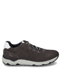 La zapatilla está hecha de cuero liso de color gris oscuro y tiene un acento blanco en el talón. Cuenta con un sistema de cordones y una suela de goma blanca robusta con detalles negros para un soporte adicional.