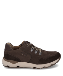Zapatilla marrón de ante con cordones y ojales metálicos. El zapato tiene una suela perfilada de color beige claro y costuras decorativas discretas para un look deportivo y elegante.