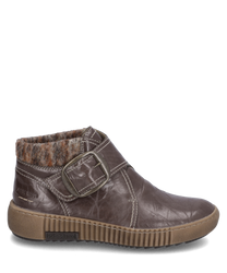 Die Stiefelette in Dunkelbraun mit Klettverschluss besteht aus Lederimitat. Sie hat ein innenliegendes warmes Futter und eine markante Schnalle an der Seite für einen stilvollen Akzent.