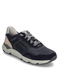 Der Sneaker ist aus glattem dunkelblauem Leder mit beigem Wildleder-Detail an der Ferse gefertigt. Er verfügt über eine markante weiße Sohle mit grauen Sprenkeln und eine Schnürung.