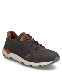 De sneaker van donkergrijs leer valt op door zijn contrasterende roestbruine details en een lichtgrijze geprofileerde zool. De schoen is voorzien van een klassieke vetersluiting en is ideaal voor casual outfits.