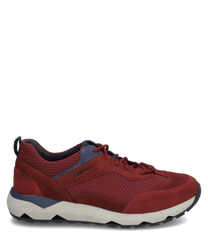 Red sneaker with lacing made of suede and textile. The shoe features a contrasting white sole and blue accents giving it a sporty look.