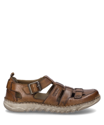Una scarpa in pelle color cognac con una fibbia distintiva come chiusura. La scarpa ha una suola robusta e aree aperte che garantiscono ventilazione.