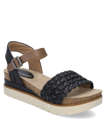 Elegante sandalo con cinturino intrecciato nero e chiusura in velcro regolabile. La suola è realizzata in materiale beige chiaro strutturato con un accento di sughero marrone.