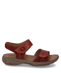 La sandalia está hecha de cuero rojo y cuenta con un práctico cierre de velcro. El zapato tiene una suela robusta de color marrón claro y ofrece una cómoda experiencia de uso.