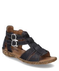The sandal is made of black leather with two silver buckles as closures. It features a decorative light brown sole with a floral pattern.