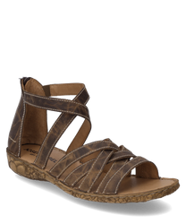 Sandale en cuir marron avec couture décorative et fermeture à glissière réglable. La semelle présente un motif floral qui ajoute un charme supplémentaire.