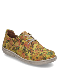 El zapato de media caña presenta un diseño floral en amarillo con patrones de flores coloridas. Está hecho de un material de tela ligero y cuenta con un cordón blanco que proporciona un ajuste personalizado.